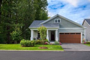 Green Daisy home with wood toned garage door