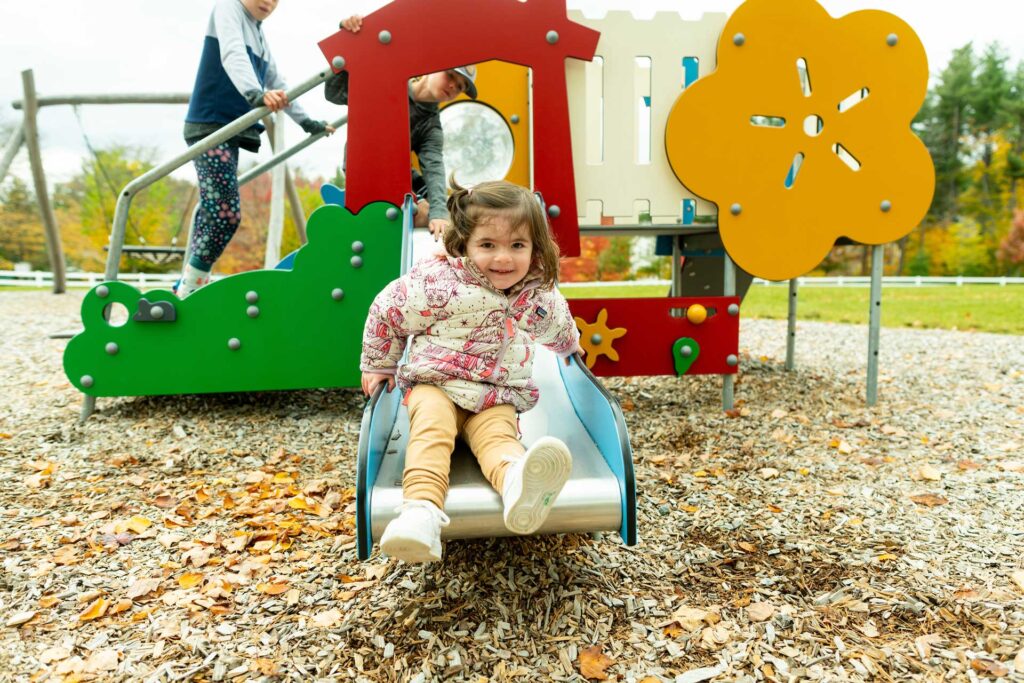 Happy girl going down slide
