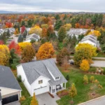 aerial view of neighborhood surrounded by peak fall foliage.