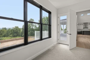 bedroom large black window tree view door to deck carpet