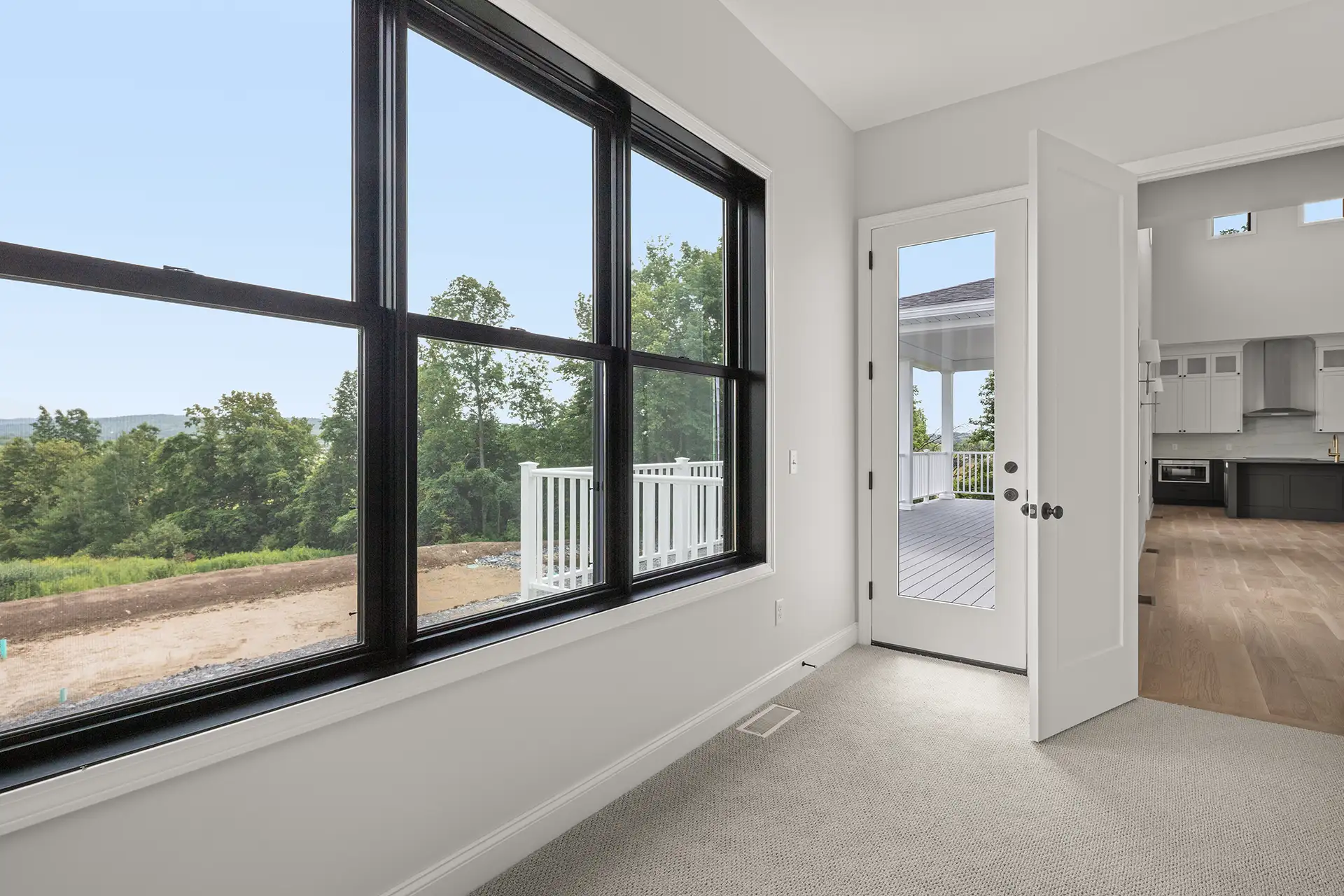 bedroom large black window tree view door to deck carpet