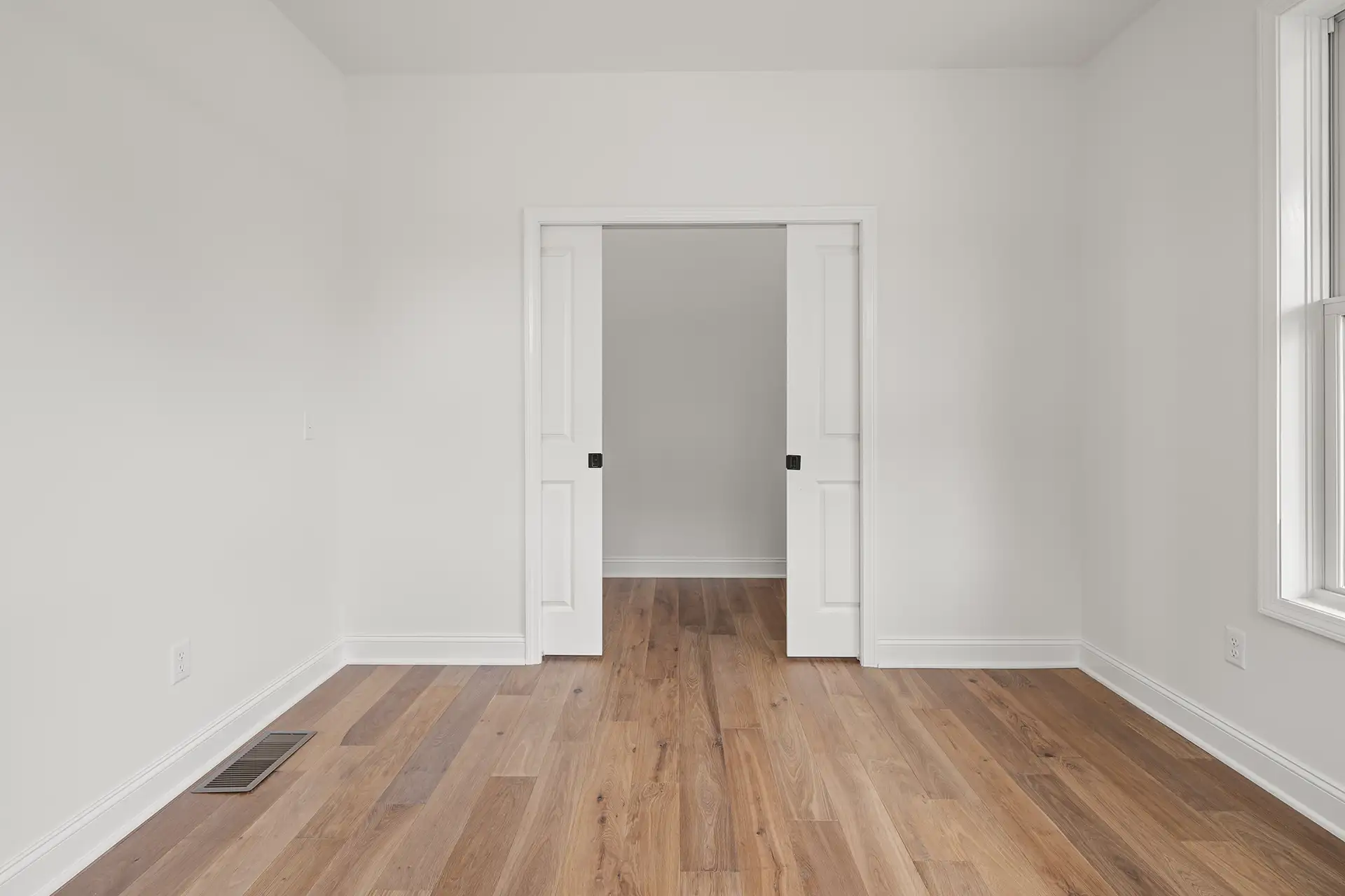 bedroom pocket doors hardwood floor side window