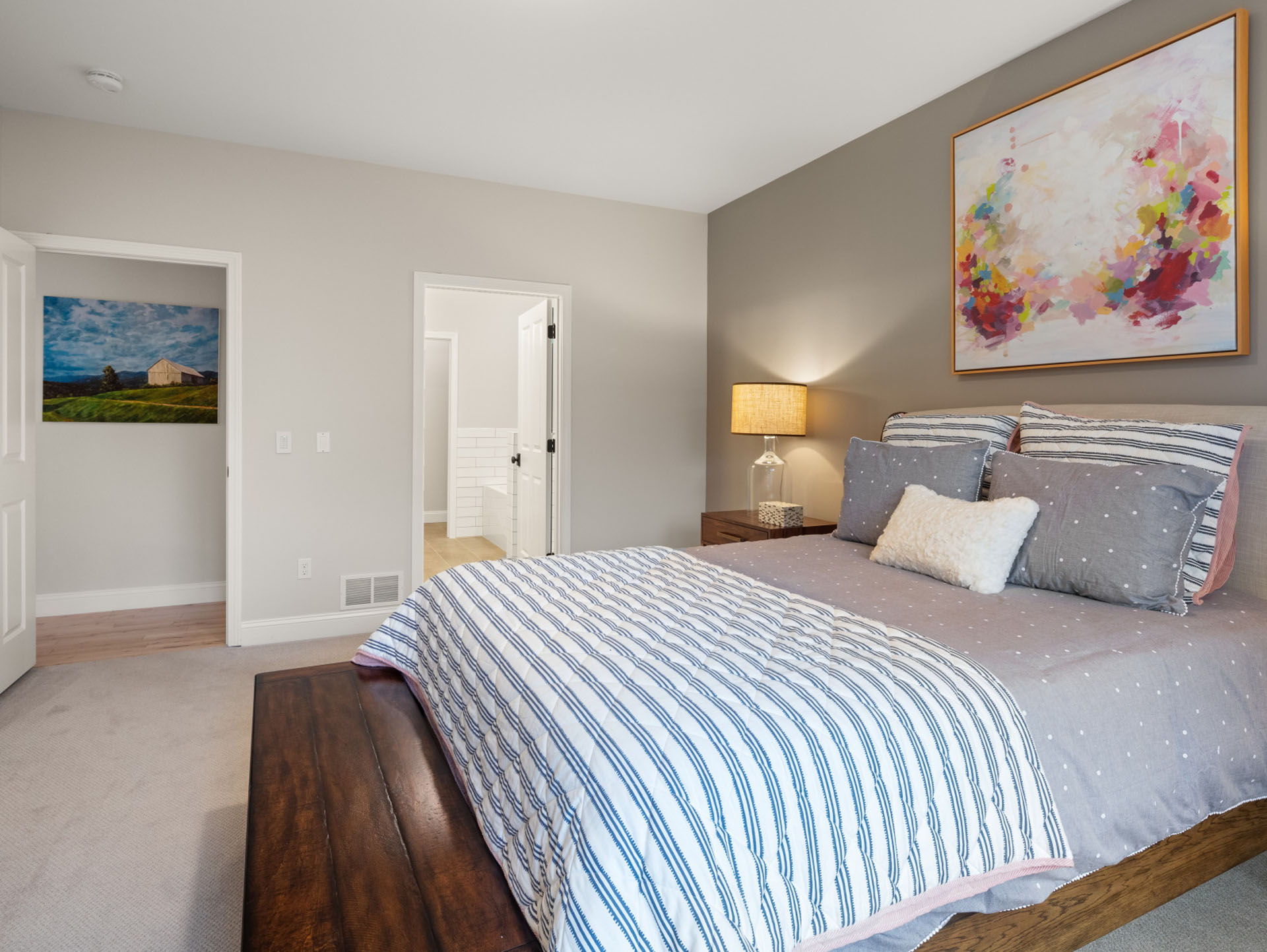 bedroom with wood sleigh bed abstract art and en suite doorway
