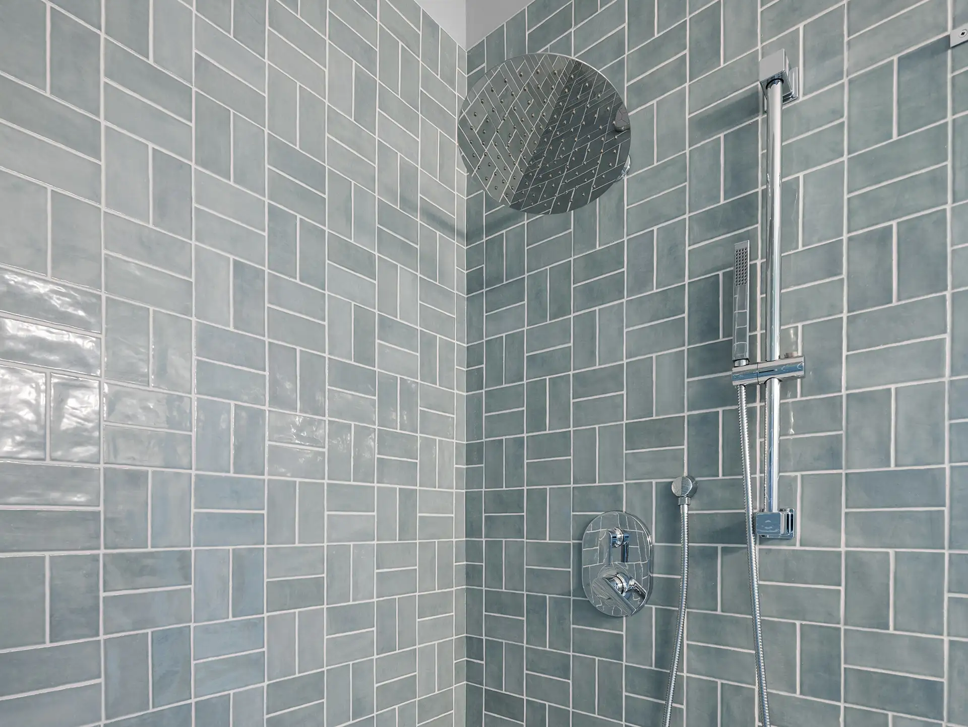 blue gray tile shower with rain head and handheld