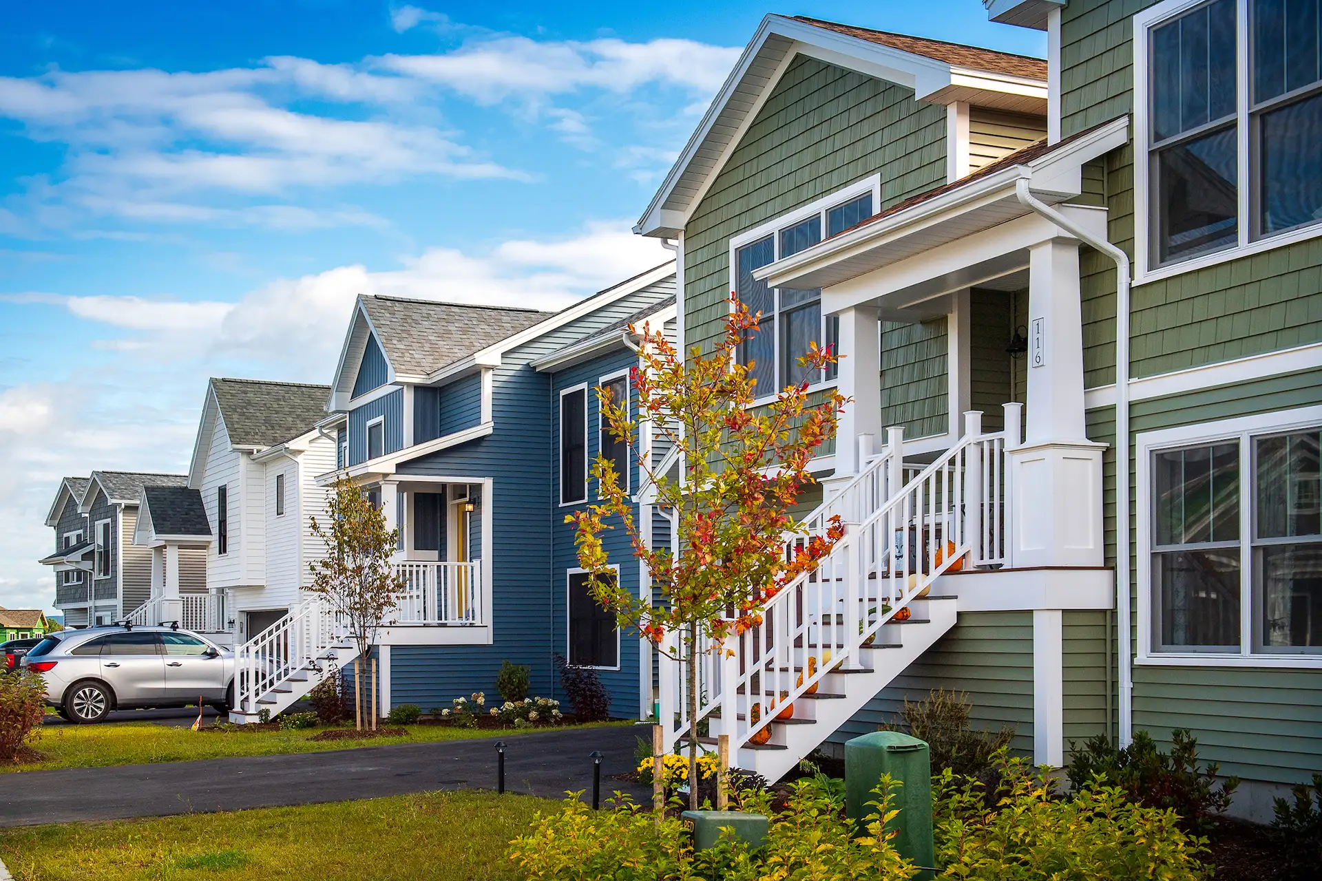 colorful row of homes with raised porches and autumn foliage