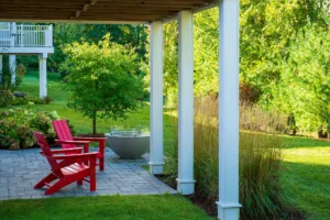 covered patio with red Adirondack chairs and concrete fire bowl