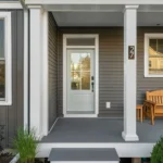 covered porch close up with glass front door and wood bench