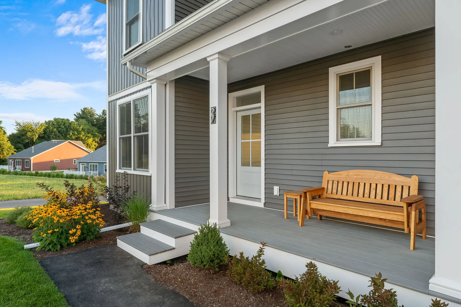 covered porch with wood bench and side table at golden hour.