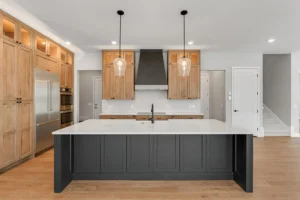 dark island front view wood cabinets black range hood staircase