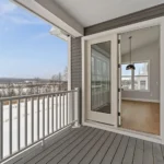 deck with glass door entry and snowy mountain view.