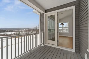 deck with glass door entry and snowy mountain view.