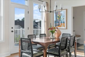 dining room with wood table cane chairs and french door to deck