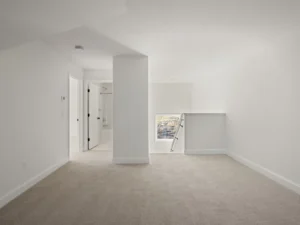 empty bedroom vaulted ceiling carpet en suite door