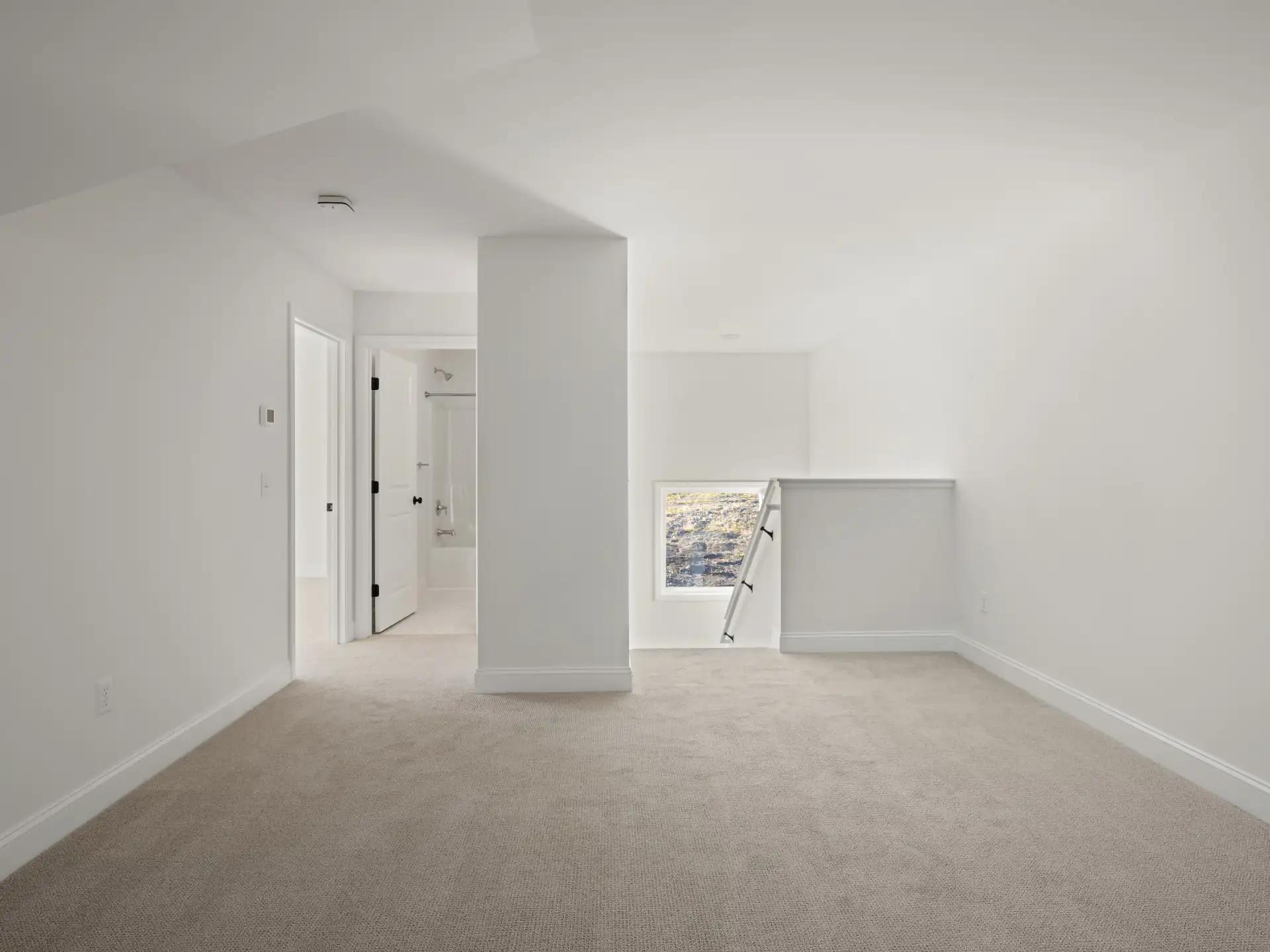 empty bedroom vaulted ceiling carpet en suite door