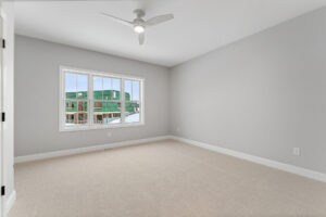 empty bedroom with white ceiling fan and construction view window