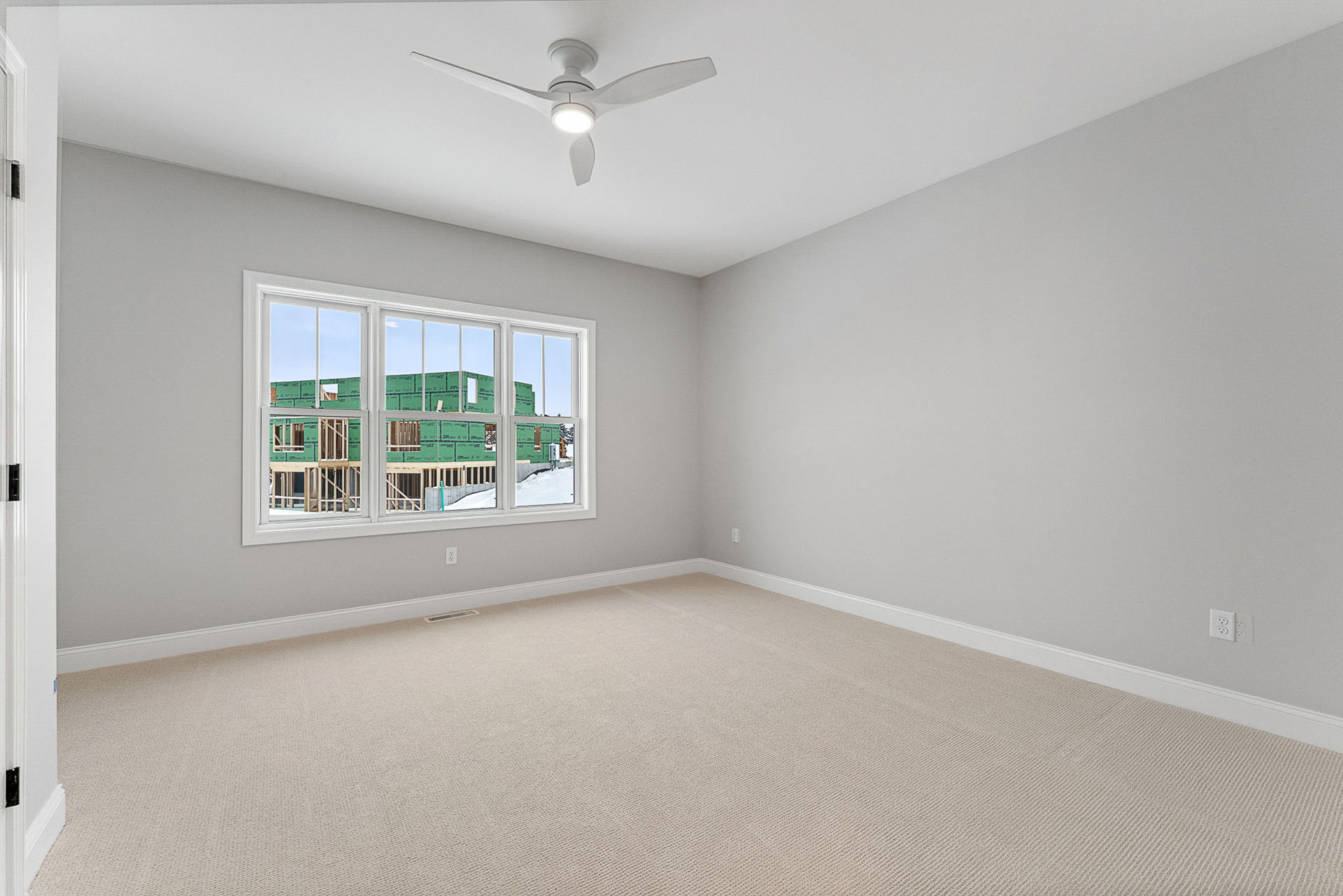 empty bedroom with white ceiling fan and construction view window