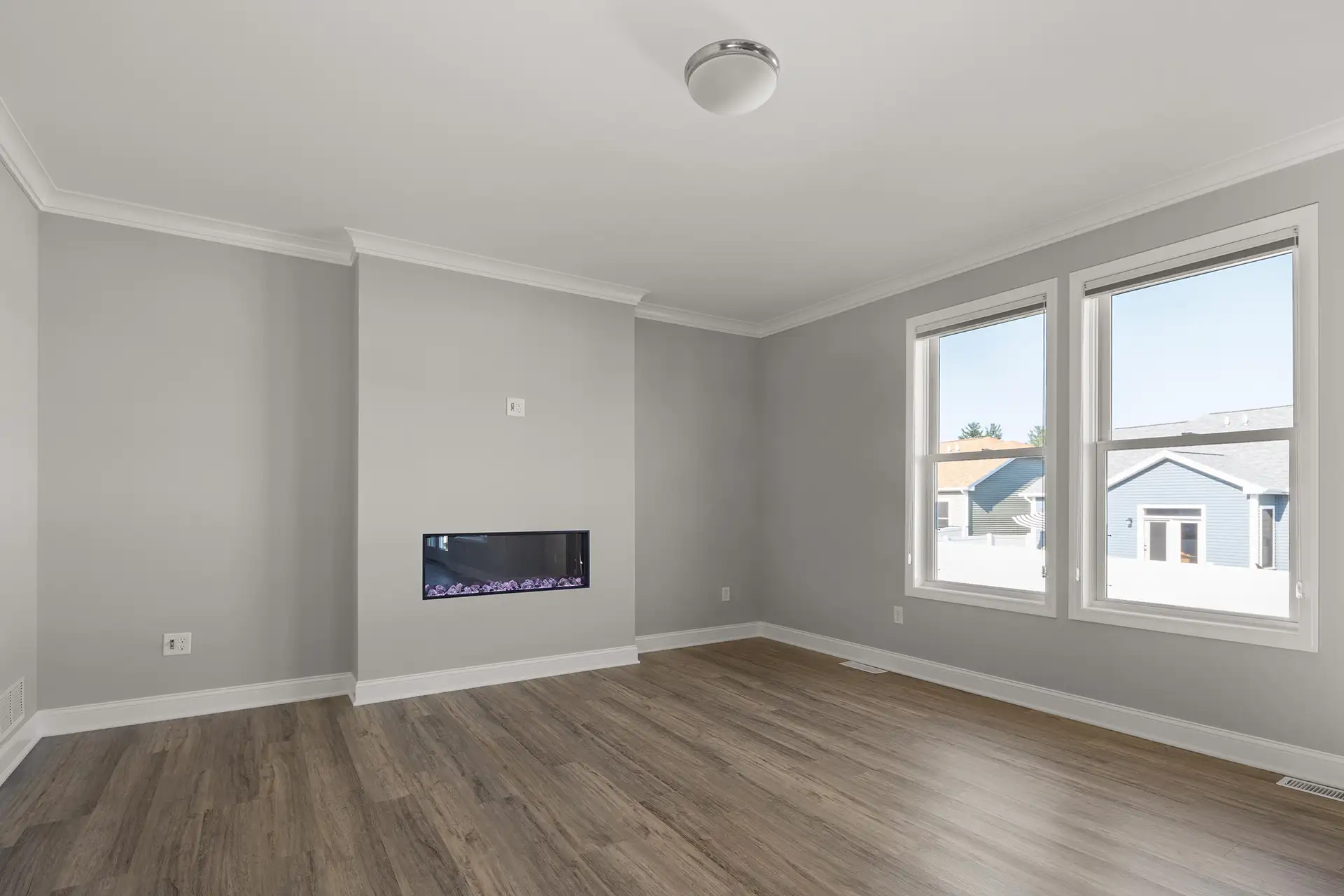 empty living room with crown molding linear fireplace and double windows