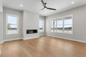 empty living room with linear fireplace black ceiling fan and deck view