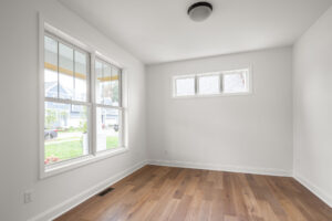 empty room with hardwood floor large window and transom window
