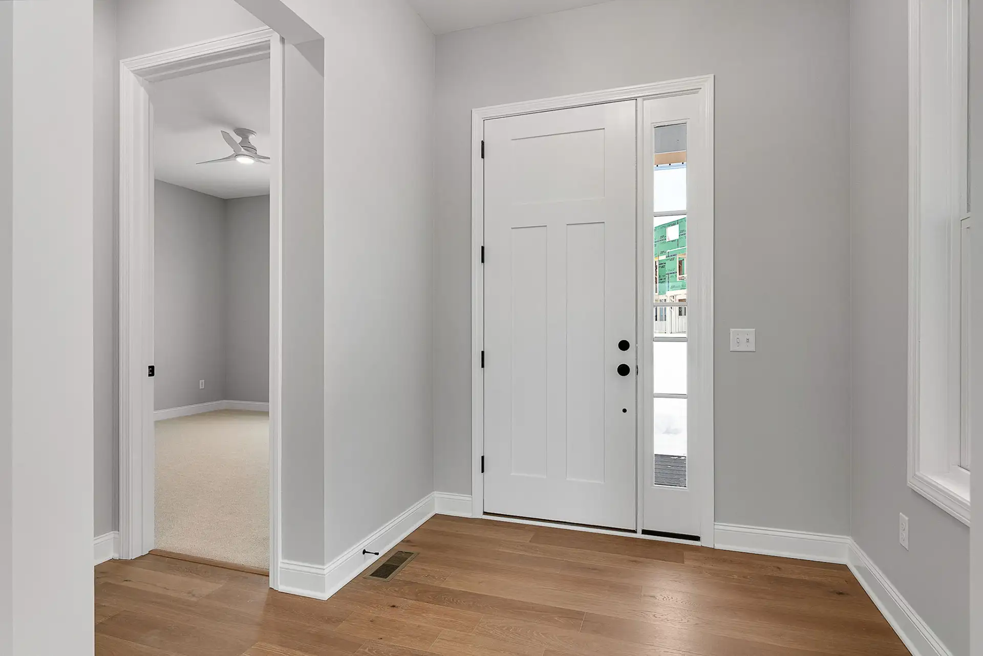 entry foyer white craftsman door sidelight hardwood floor