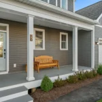 front porch with wood bench and garage side angle view