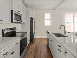 galley kitchen white cabinets stainless appliances two windows