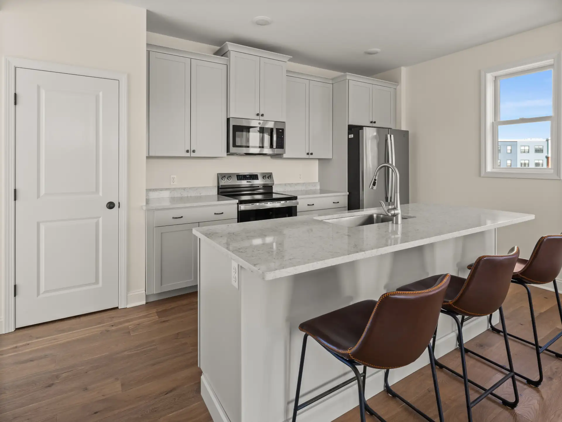 gray kitchen island leather barstools stainless appliances