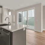 gray kitchen island with sink and sliding glass door to deck