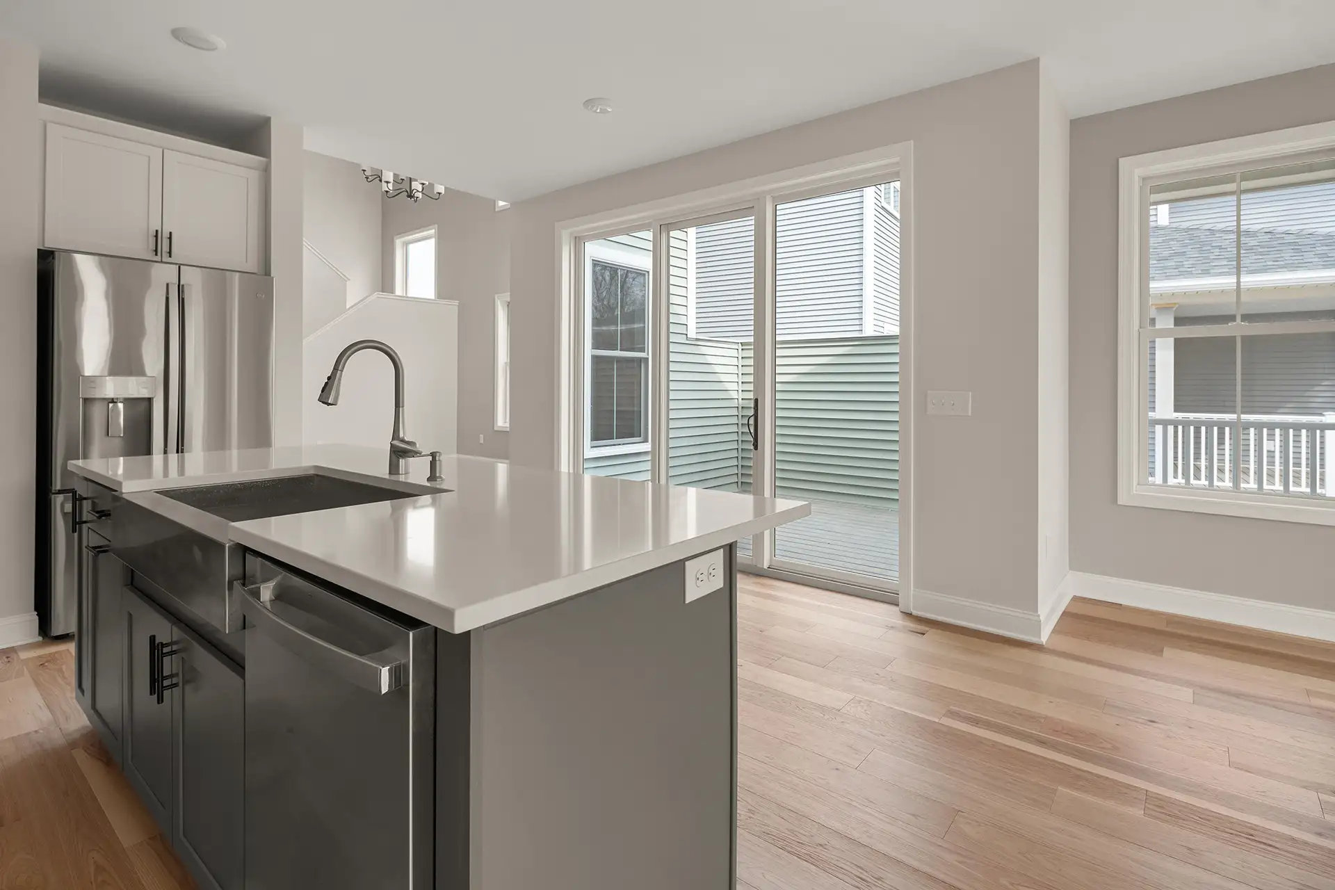 gray kitchen island with sink and sliding glass door to deck