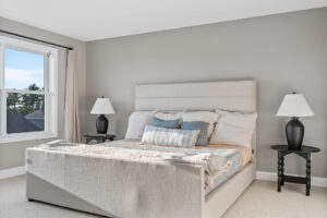 gray primary bedroom with upholstered bed and black nightstands