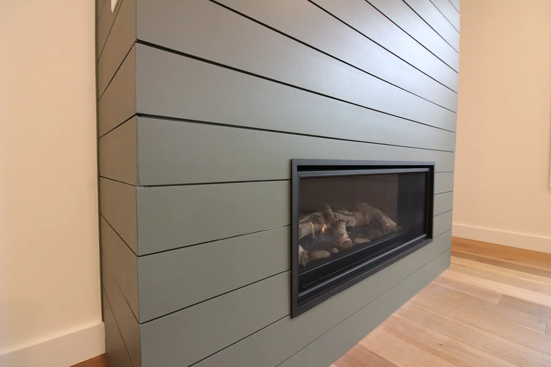 gray shiplap fireplace wall with linear gas insert close up
