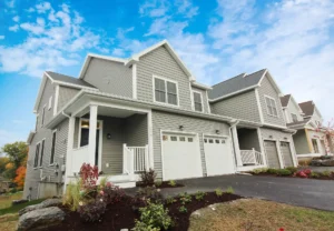 gray siding townhome exterior with covered porch and two car garage