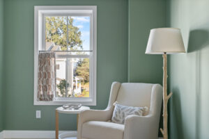 green nursery reading nook with armchair and tree branch lamp