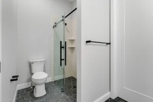 hex tile bathroom sliding glass shower toilet view