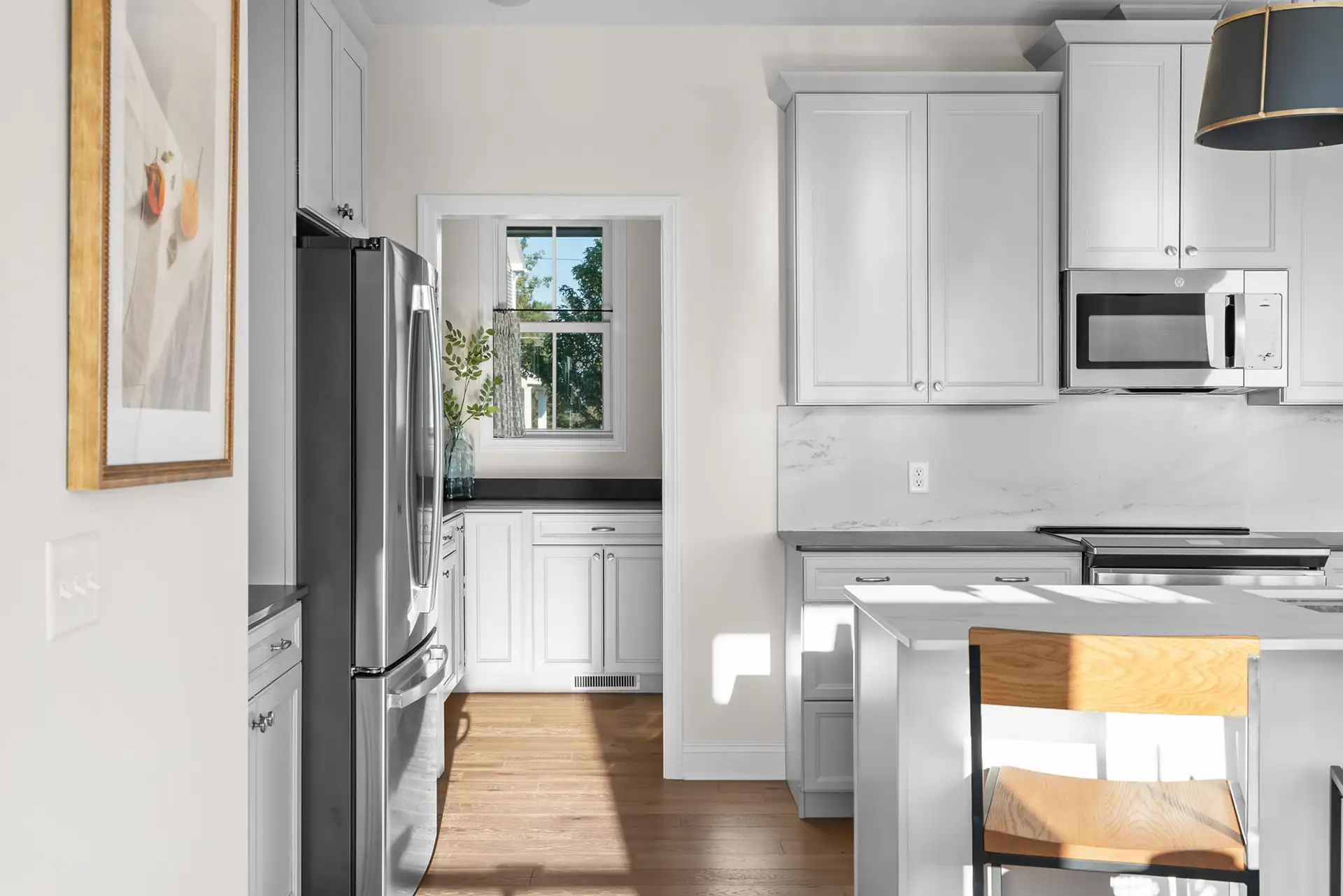 kitchen view toward pantry stainless fridge marble backsplash