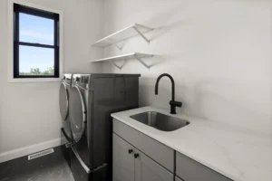 laundry room dark washer dryer sink marble counter shelves