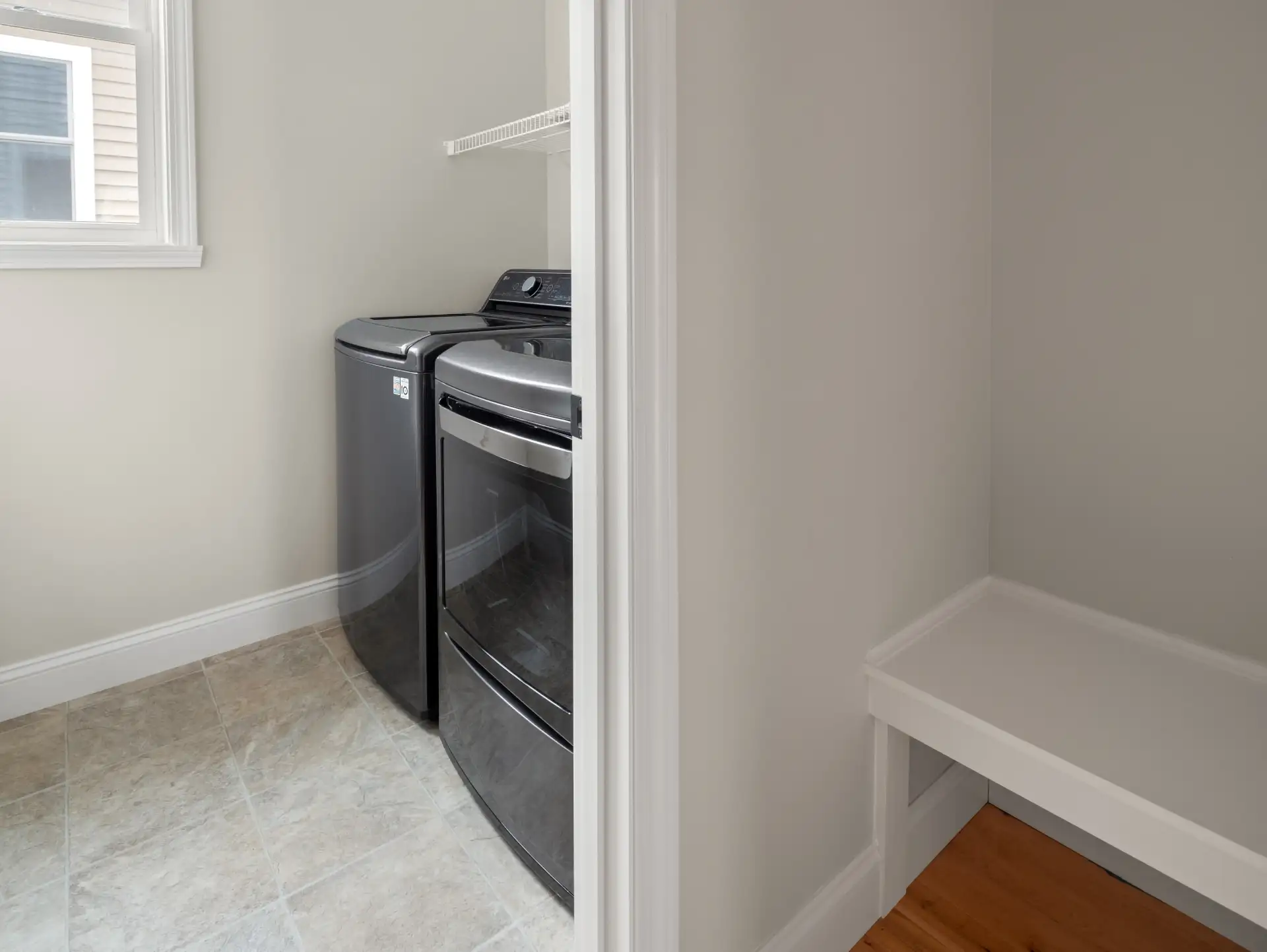 laundry room top load washer dryer tile floor shelf nook
