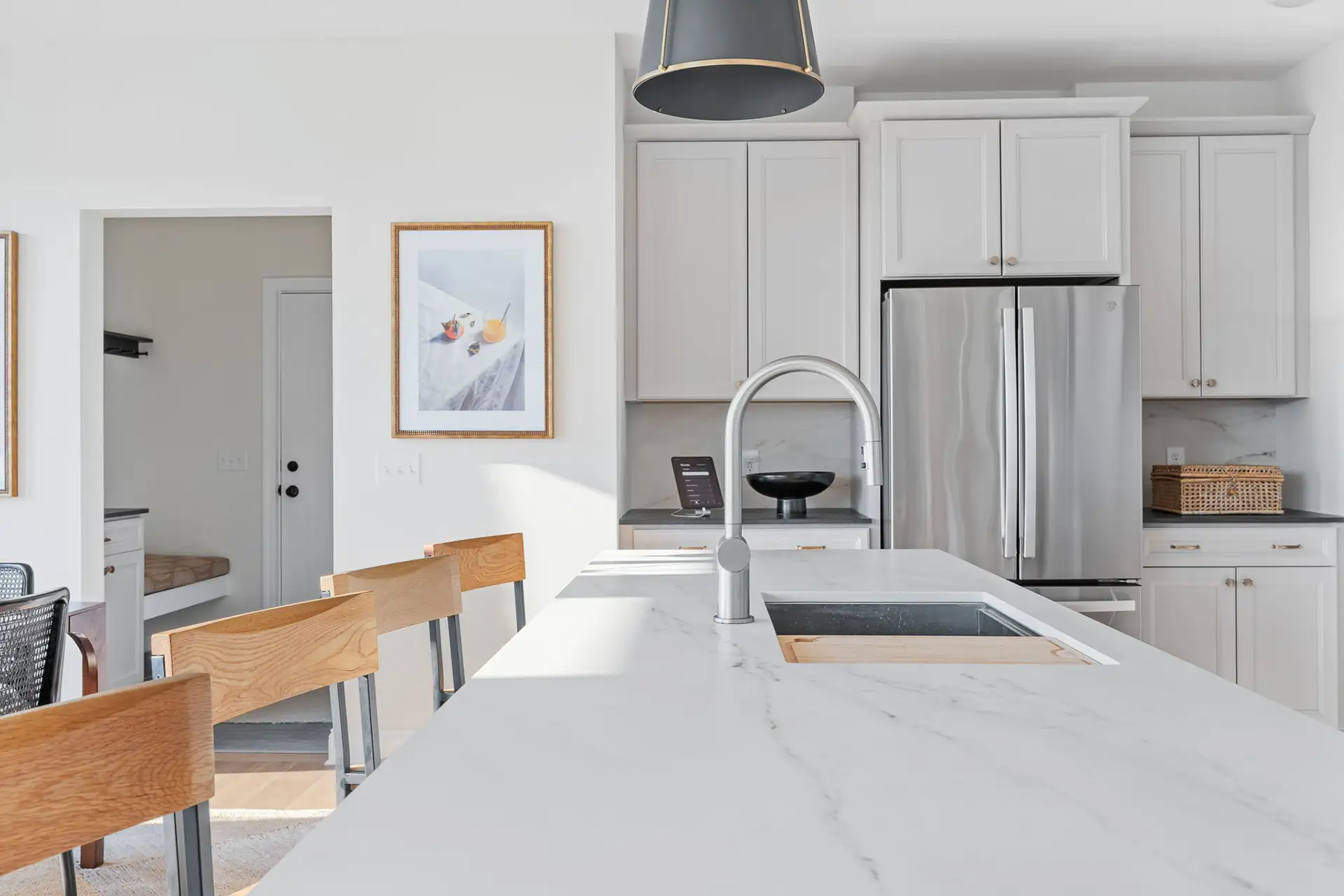 marble island countertop closeup gray cabinets framed art