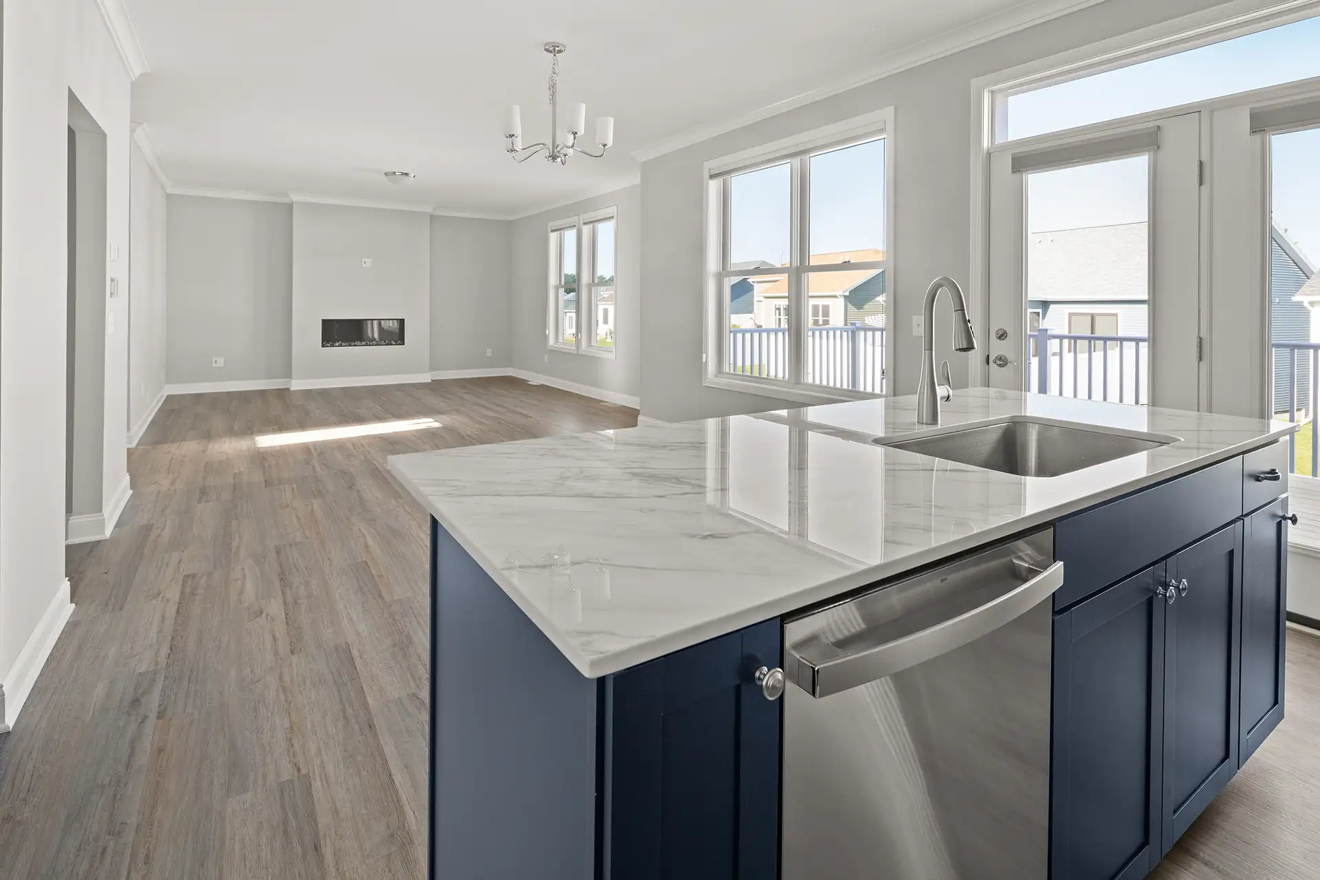 navy kitchen island with marble countertop and open living room fireplace