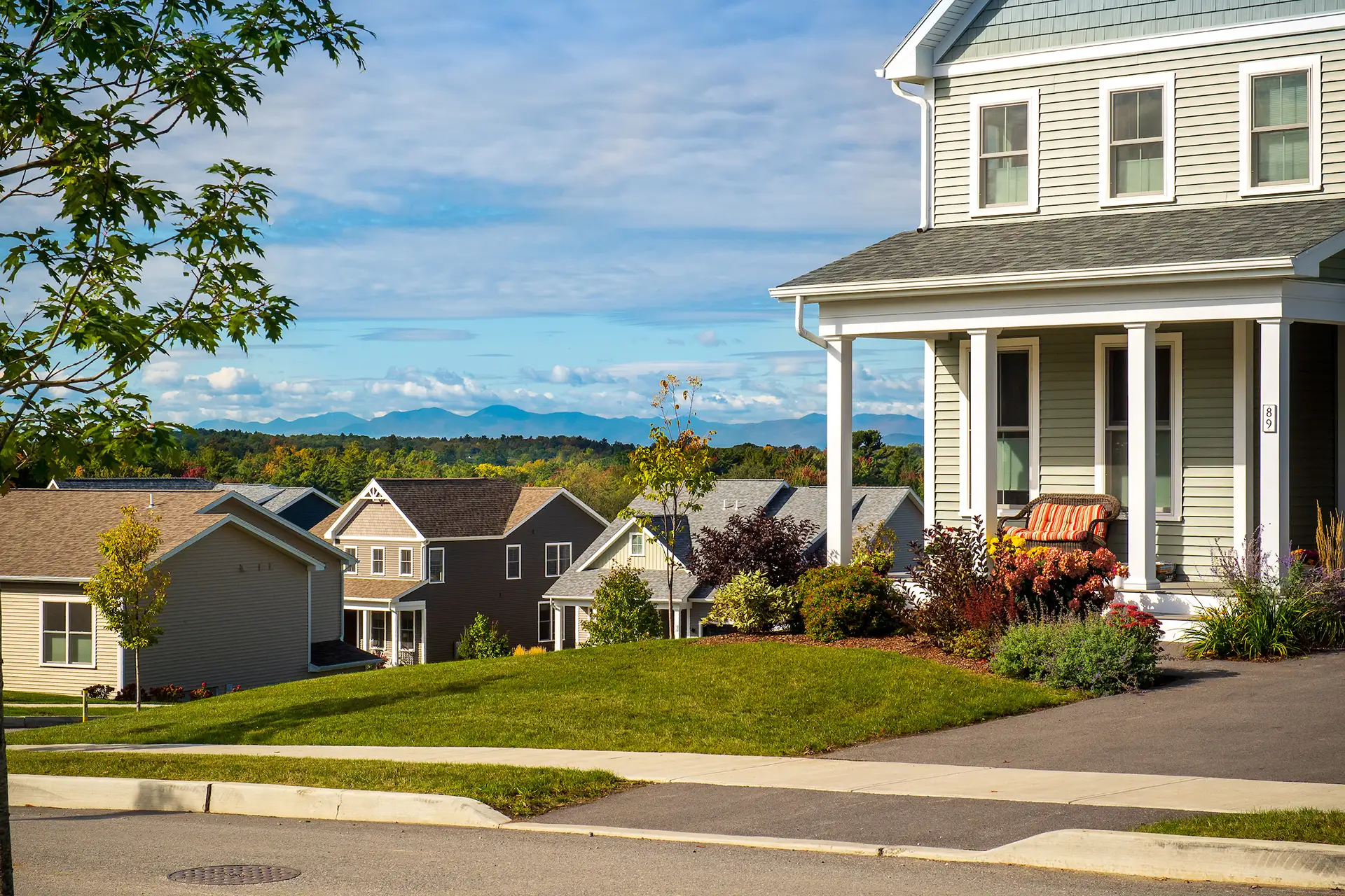 neighborhood street with mountain view and wrap porch home