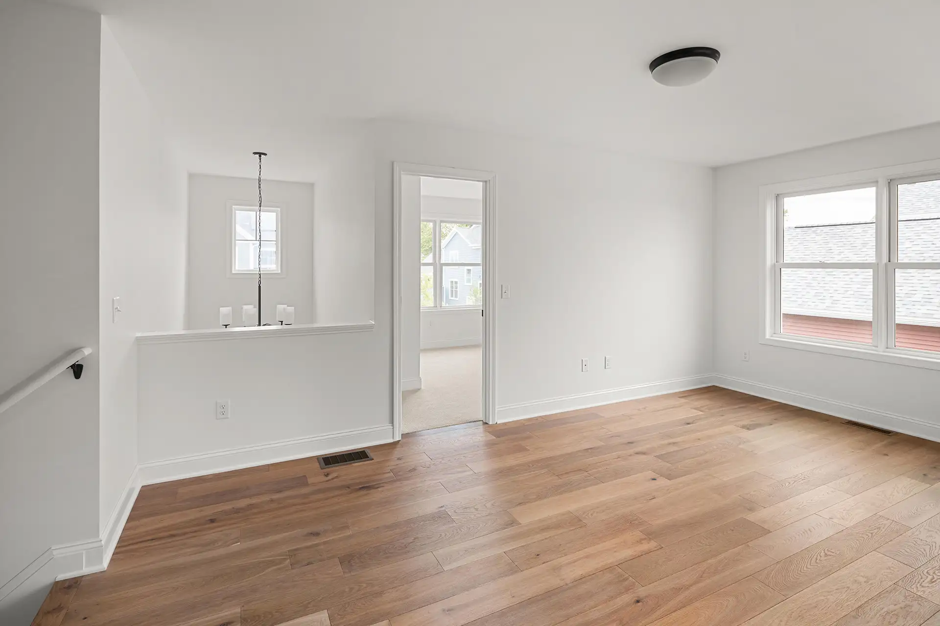 open hallway hardwood floor pendant light staircase