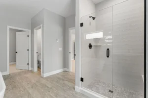 open plan bathroom grey walls glass shower entry