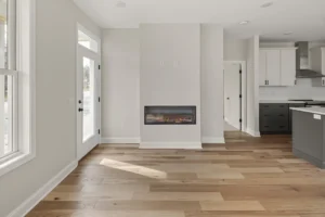 open plan living linear fireplace dark kitchen cabinets