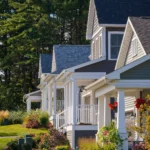 row of craftsman homes with covered porches and flower gardens