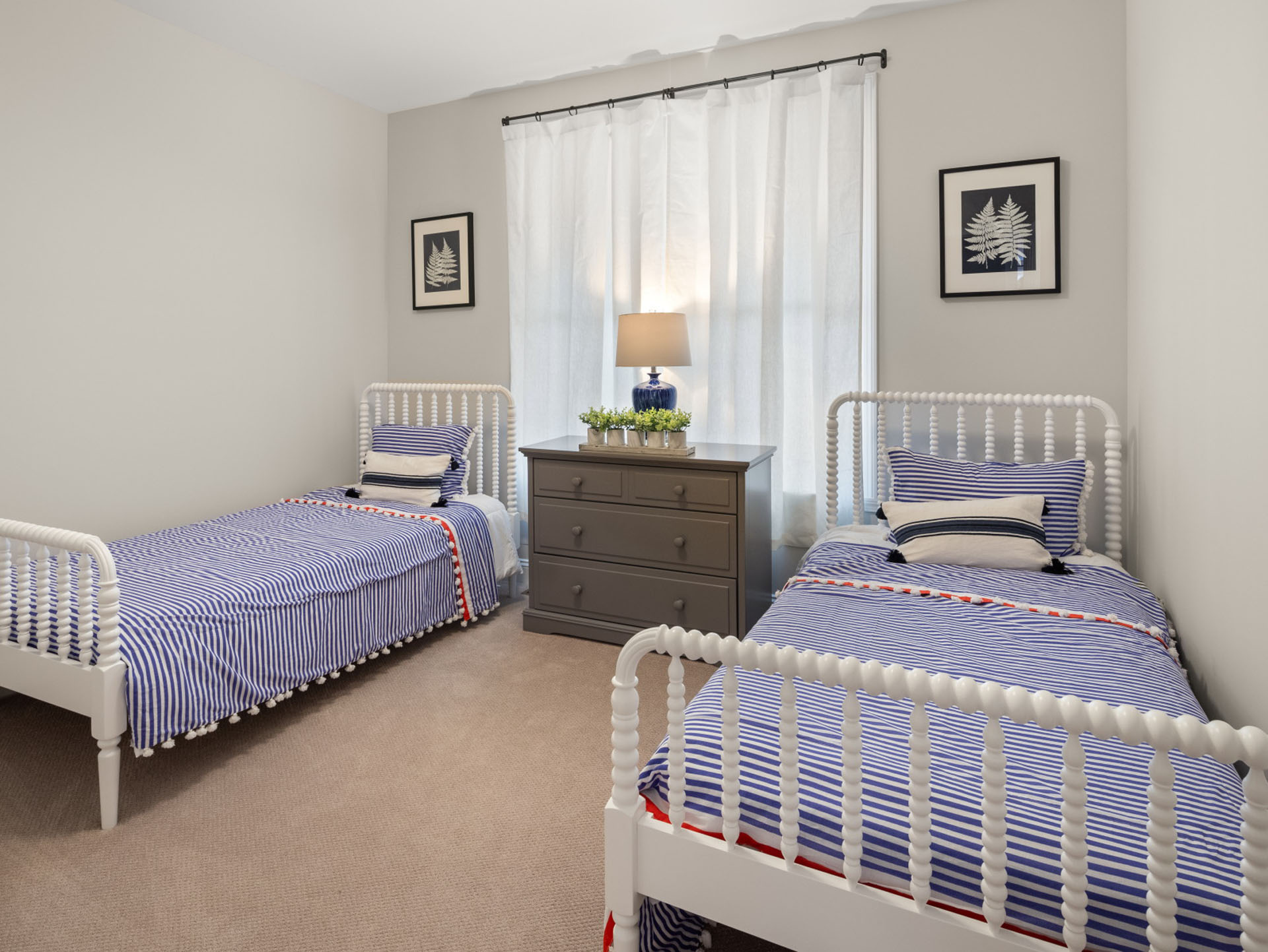 shared bedroom with two spindle twin beds and blue striped bedding