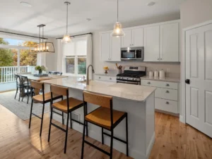 staged kitchen wood barstools glass pendants deck view