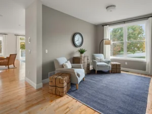 staged sitting room two armchairs blue rug wall clock window
