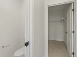toilet area with open door to carpeted walk in closet