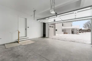 white modern farmhouse exterior with black garage doors and covered porch
