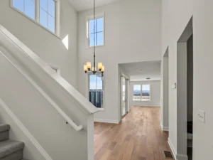 two story foyer with staircase chandelier and hallway to back deck